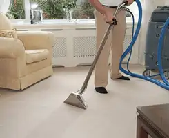 Carpet cleaning professional removing dirt and stains with a hot-water extraction tool in a home, Boulder, CO.